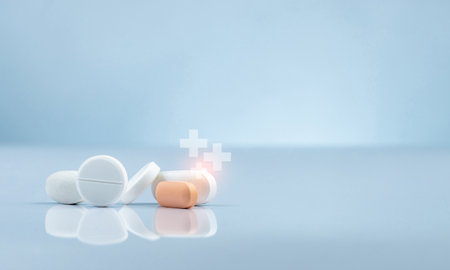 White and orange pharmaceutical tablets with medical cross symbols. Pharmacy drugstore and healthcare industry. Pharmaceutical retail market and medical industry. Hospital and drugstore marketing.の写真素材