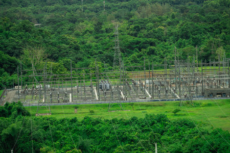Electrical power station at hydroelectric dam facility with green forest. Sustainable renewable...