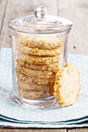Walnut cookies in a glass jar on blue napkinの写真素材