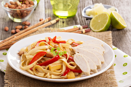 Udon noodles with bell pepper, peanut and chickenの写真素材