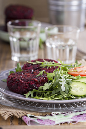 Vegan burgers with beetroot and beans served with fresh vegetablesの写真素材