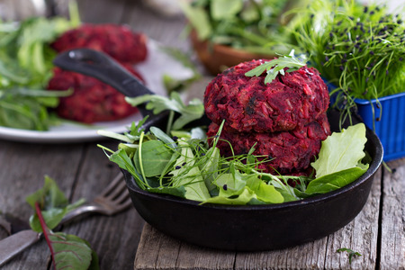 Vegan burgers with beetroot and beans served with fresh vegetablesの写真素材