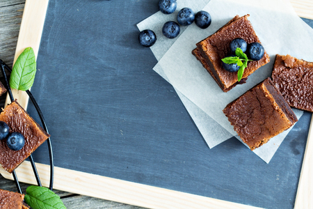 Brownies with blueberries on a chalkboardの写真素材