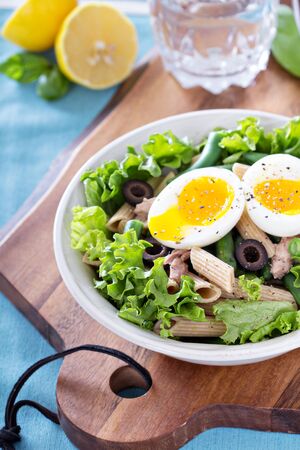 Salad with greens, pasta, tuna and boiled eggの写真素材