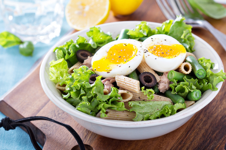Salad with greens, pasta, tuna and boiled eggの写真素材