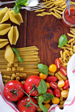 Pasta background different types with tomatoes and basil top viewの写真素材