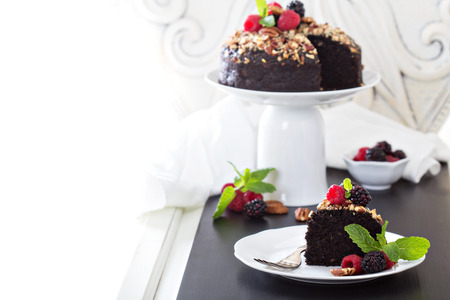 Chocolate banana cake with nuts decorated with berriesの写真素材