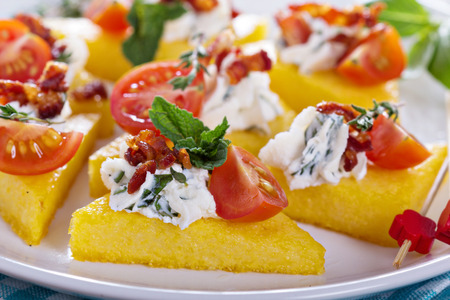 Polenta appetizers with ricotta and baconの写真素材