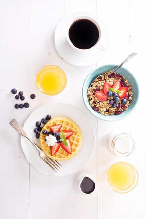 Breakfast waffles with fresh berries stacked on a plate