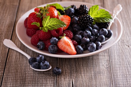 Variety of summer berries on a white plateの写真素材