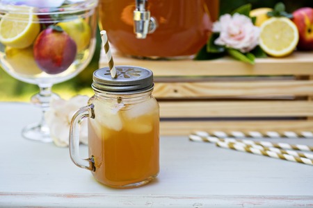 Peach cardamom lemonade with ice cubes in mason jar mugの写真素材
