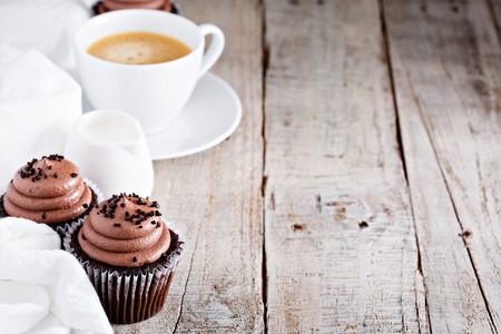 Chocolate cupcakes with a cup of hot black coffeeの写真素材