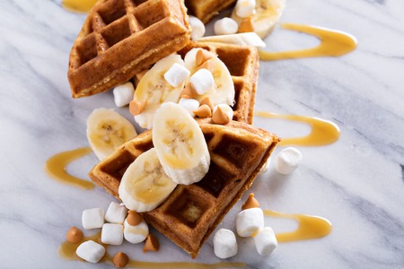 Waffles with peanut butter and bananas topped with caramel syrupの写真素材