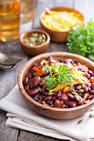 Vegetarian chili with red and black beans, cheddar and pumpkin seedsの写真素材
