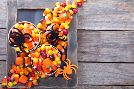 Halloween candy in small tins on brown rustic table overheadの写真素材