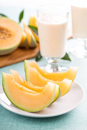 Ripe fresh cantaloupe slices on white plateの写真素材