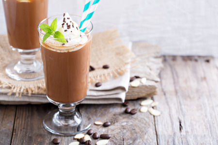 cappuccino in a glass with whipped cream and almond milk