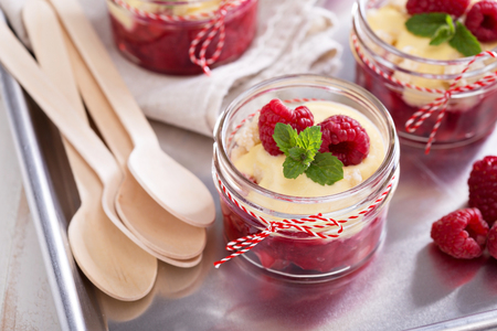 Colorful and delisious dessert in a jar berry cramble with vanilla sauceの写真素材
