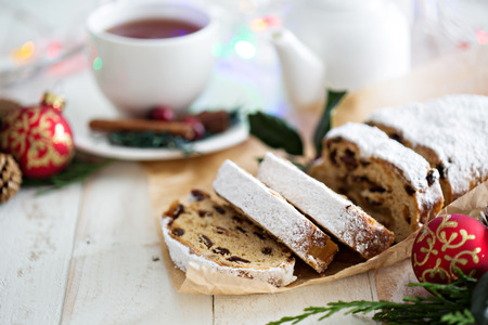 Christmas stollen with dried fruits and marzipan served with tea and decorations