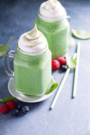 Green smoothie with whipped topping in mason jarsの写真素材
