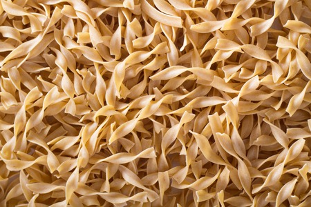 Egg pasta background with small pasta shapes