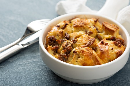 Breakfast strata with cheese and sausage in small baking dishの写真素材