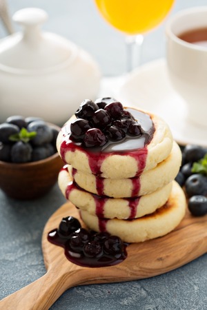 Small cottage cheese pancakes with blueberry sauceの写真素材