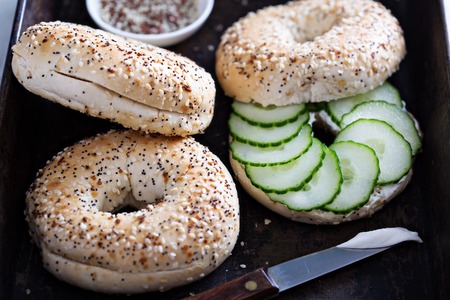 Everything bagels with seeds served with cream cheese and cucumberの写真素材