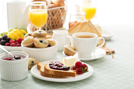 Fresh and bright continental breakfast table with jam on toast
