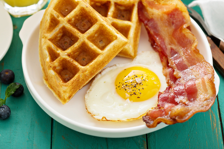 Southern cuisine breakfast with waffles, bacon and eggの写真素材
