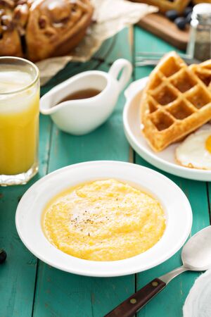 Cheesy grits with butter in a white bowl for breakfastの写真素材