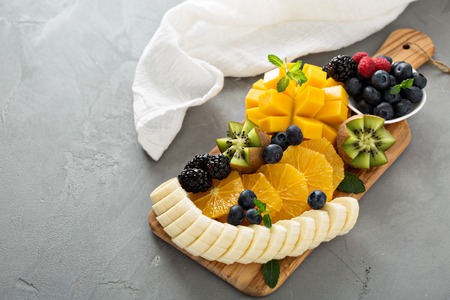 Fruit plate with berries, banana, mango and kiwiの写真素材