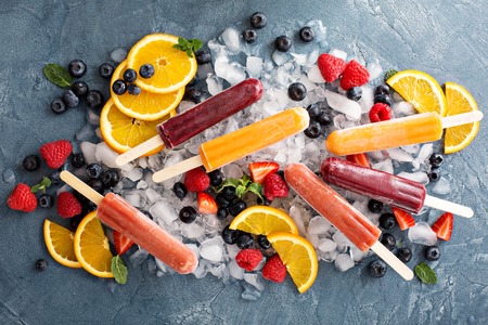 Variety of healthy ice popsicles with fruits and berries on iceの写真素材