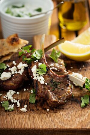 Lamb chops with herbs, lemon, pita bread and fetaの写真素材