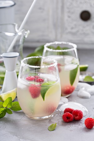 Cold summer refreshing cocktail with limes and raspberryの写真素材