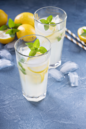 Classic lemonade with mint and lemon slices on blue backgroundの写真素材