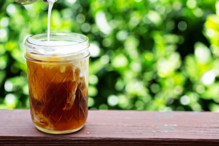 Iced coffee in mason jars outdoors on the front porch