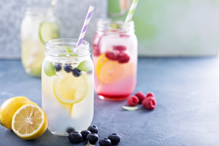 Variety of lemonade in mason jars with berries and fruitsの写真素材