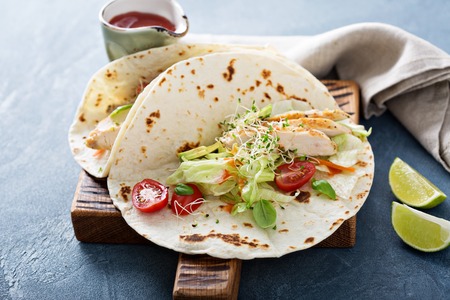 Chicken tacos with salad leaves and tomatoes