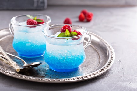 Blue raspberry cocktail with mint in small glass cupsの写真素材