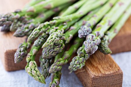 Bunch of green asparagus on a cutting boardの写真素材