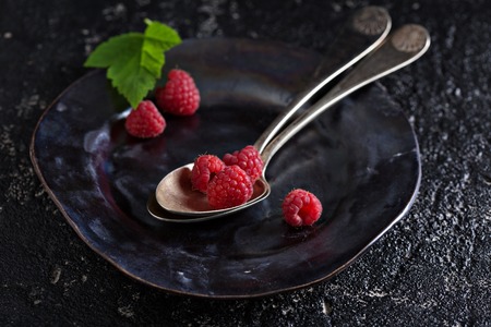 Fresh raspberry in a vintage spoon on dark backgroundの写真素材