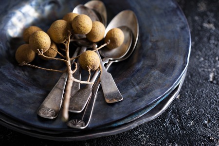 Black handmade ceramic plates with old vintage spoonsの写真素材