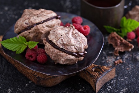 Meringue dessert with chocolate and raspberries on dark backgroundの写真素材