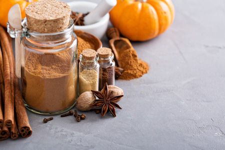 Homemade pumpkin pie spice in a glass jar with ingredientsの写真素材