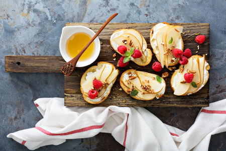 Pear bruschetta with cream cheese, nuts and honeyの写真素材