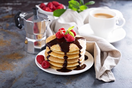 Stack of fluffy buttermilk pancakes with fresh raspberry and chocolate syrupの写真素材