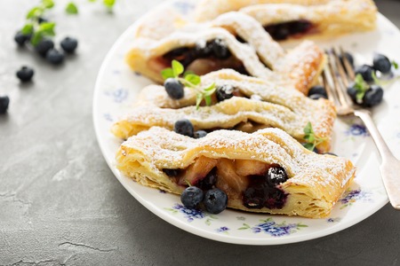 Puff pastry with apple and blueberry decorated with powdered sugarの写真素材