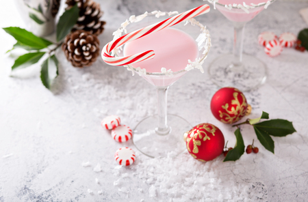 Peppermint martini cocktail with coconut flakes rim and candy caneの写真素材