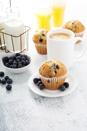 breakfast with blueberry muffin, big cup of coffee and milk in bottlesの写真素材